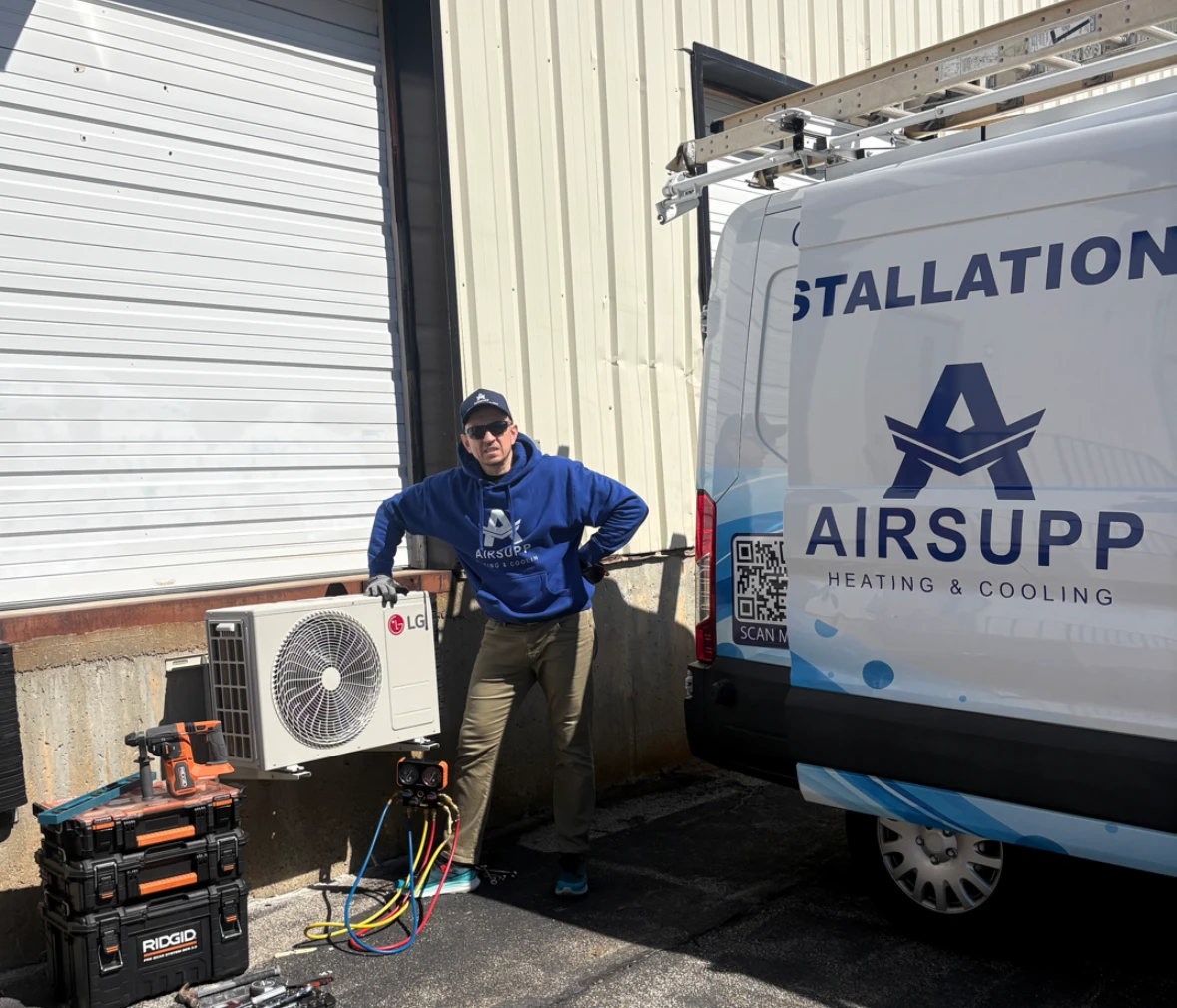 My dad, the owner of AirSupp, standing beside an outdoor heat pump unit and the AirSupp van.